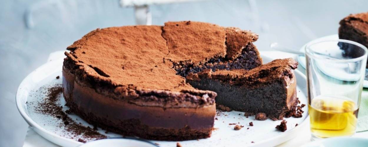 Angeschnittener runder Schokoladenkuchen auf einer Kuchenplatte