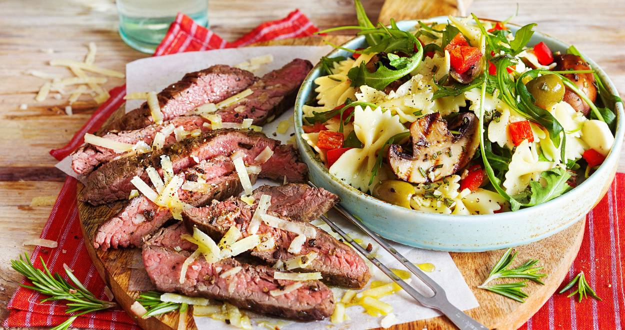 Italienischer Salat in einer Schüssel, daneben Grillfleisch