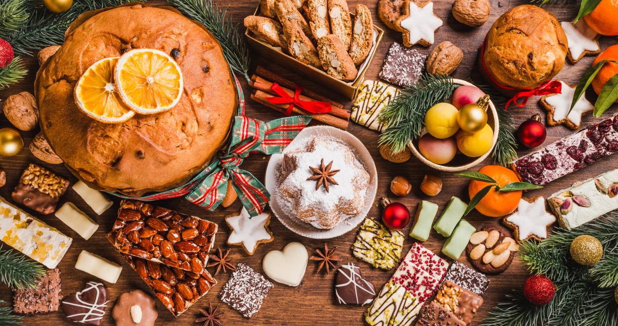 Verschiedene Weihnachtsplätzchen und Kuchen auf einem Holztisch in einer italienischen Küche