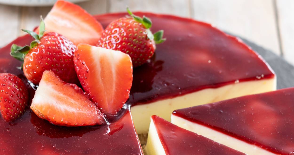 Runder Erdbeer-Panna cotta Cheesecake ohne Backen angeschnitten auf einer Schieferplatte