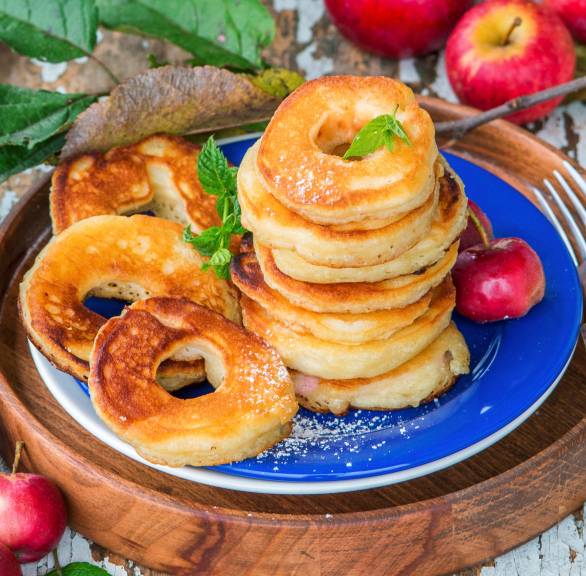 Apfelringe im Pfannkuchenteig gebacken gestapelt auf einem Teller