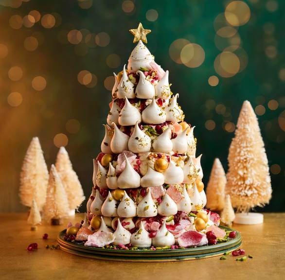 Selbst gemachter Baiser-Tannenbaum auf einem weihnachtlich dekorierten Tisch