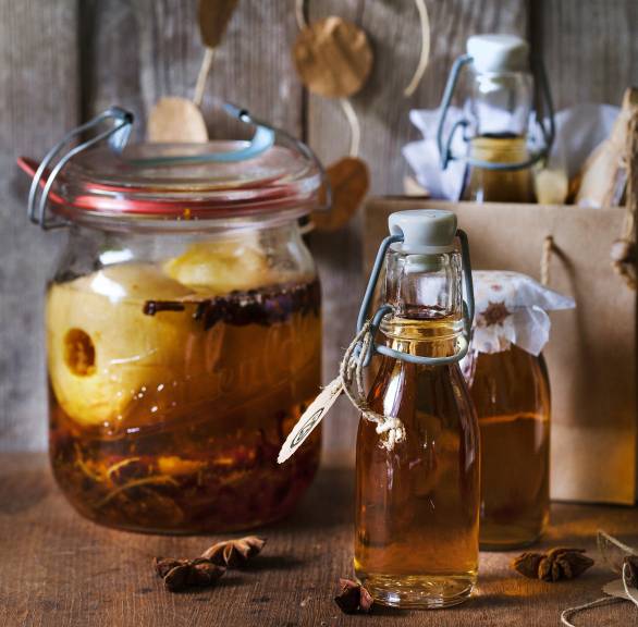 Bratapfellikör in mehrere Flaschen gefüllt, daneben eine weihnachtliche Geschenktüte