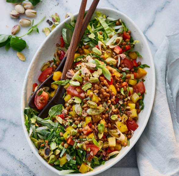 Veganer Balsamico-Linsensalat getoppt mit Pistazien in einer Salatschüssel auf einem Tisch