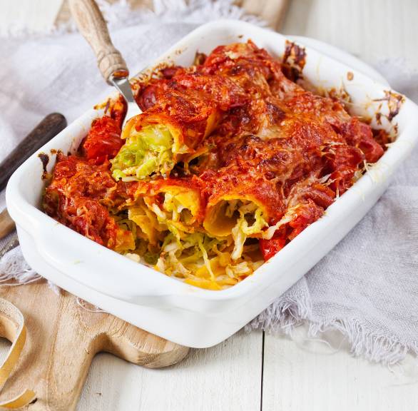 Auflauf aus Cannelloni mit Wirsingfüllung und Käsekruste auf einem Tisch
