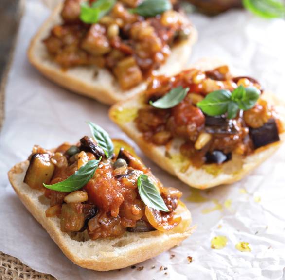 Caponata auf halbierten Ciabatta-Brötchen garniert mit frischem Basilikum
