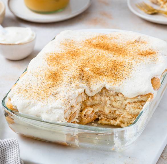 Apfeltiramisu mit Mascarpone und Löffelbiskuit angeschnitten in einer Auflaufform und mit Zimtzucker bestreut