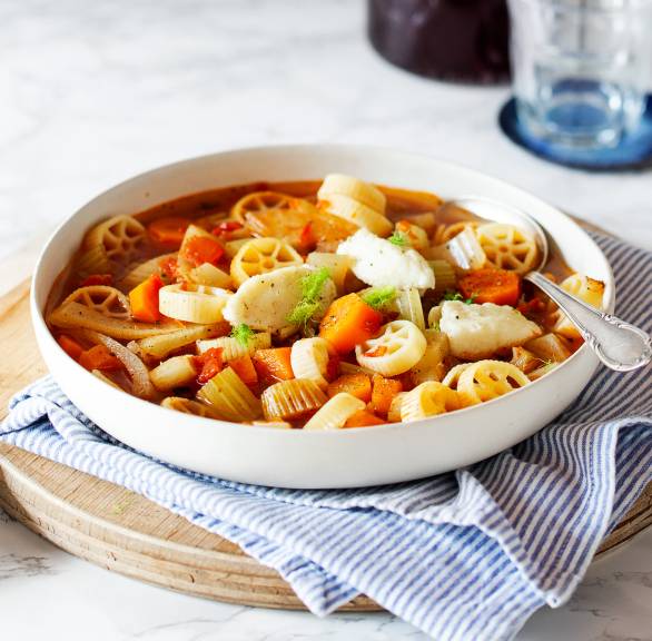 Winter-Minestrone in einer Suppenschüssel mit Einlage aus mit Rotelle-Nudeln und Pecorino-Grießnocken