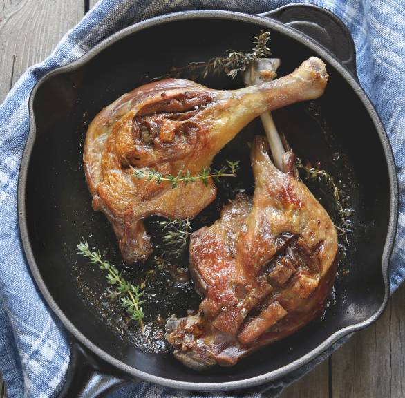 Zwei Entenkeulen in einer Pfanne garniert mit Thymian