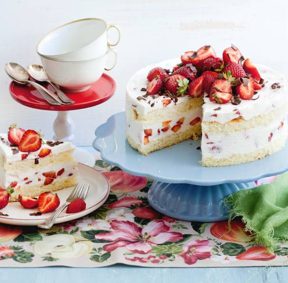 Zweistöckige Erdbeer-Joghurt-Torte mit Biskuit angeschnitten auf einer Tortenplatte
