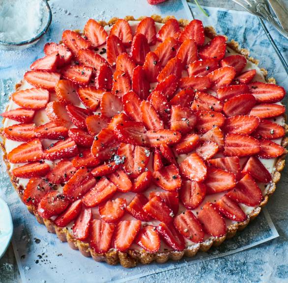 Runder italienischer Erdbeerkuchen mit frischen Erdbeeren und Ziegenfrischkäse-Sahne-Füllung auf einer Kuchenplatte