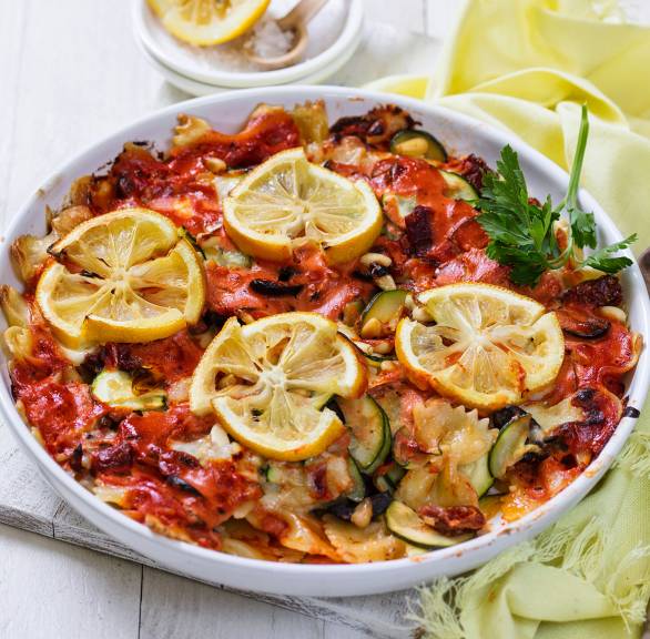 Nudelauflauf mit Zucchini garniert mit Salzzitronenscheiben auf einem Tisch