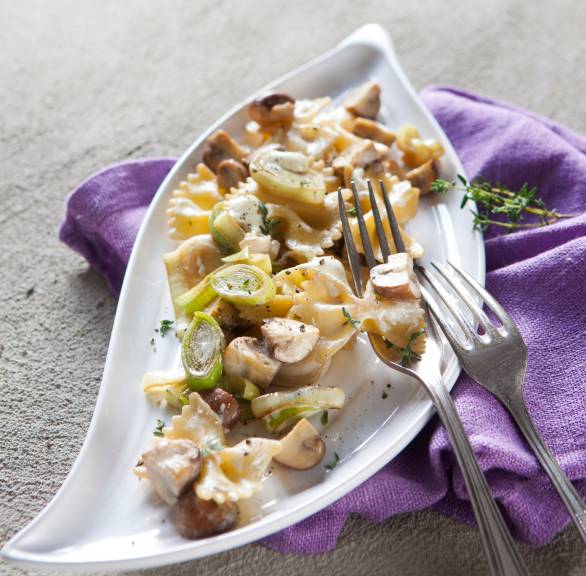 Farfalle mit Lauch in Champignon-Rahm-Sauce angerichtet auf einem Teller
