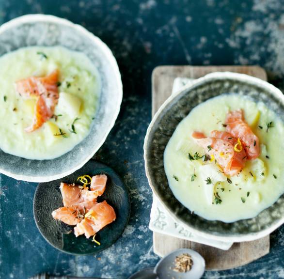 Blumenkohlsuppe mit Fenchel in zwei Schüsseln getoppt mit Räucherlachs und Kräutern auf einem Tisch
