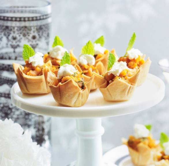 Mehrerer selbstgebackene Filoteig-Törtchen gefült mit Süßkartoffeln, Ziegenfrischkäse und Honig getoppt von Minzblättern auf einer Etagere