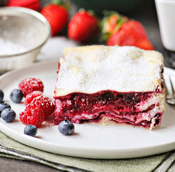 Ein Stück süße Lasagne mit Beerenschichten auf einem Dessertteller