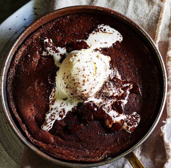 Schoko-Ricotta-Pudding in einer Pfanne getoppt mit Vanilleeis auf einem Tisch