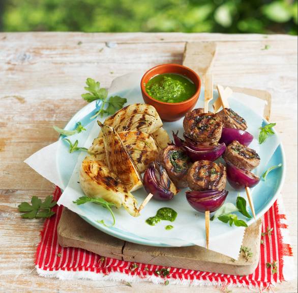 Gegrillter Fenchel und gegrillte Rindfleischspieße auf einem Teller, daneben grünes Pesto