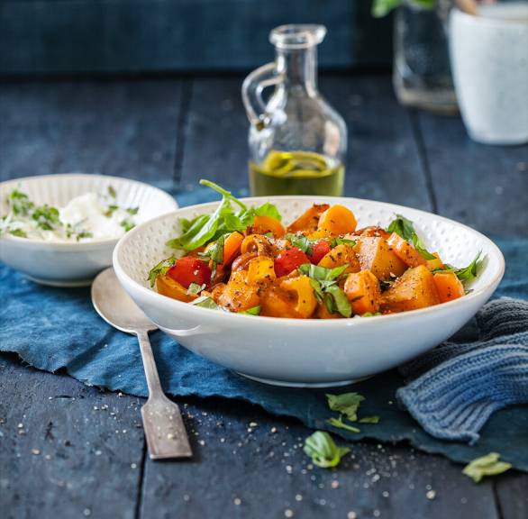 Kartoffelragout mit Gemüse und Mascarpone-Sauce angerichtet auf einem tiefen Teller