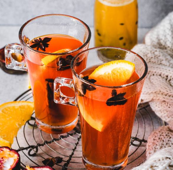 Selbst gemachter Glüh-Aperol in zwei hohen Gläsern auf einem Tisch