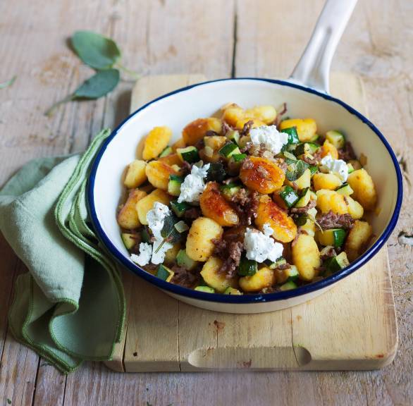 Gnocchi-Pfanne mit Hackfleisch in einer Pfanne auf einem Tisch, getoppt von Feta und Salbei daneben