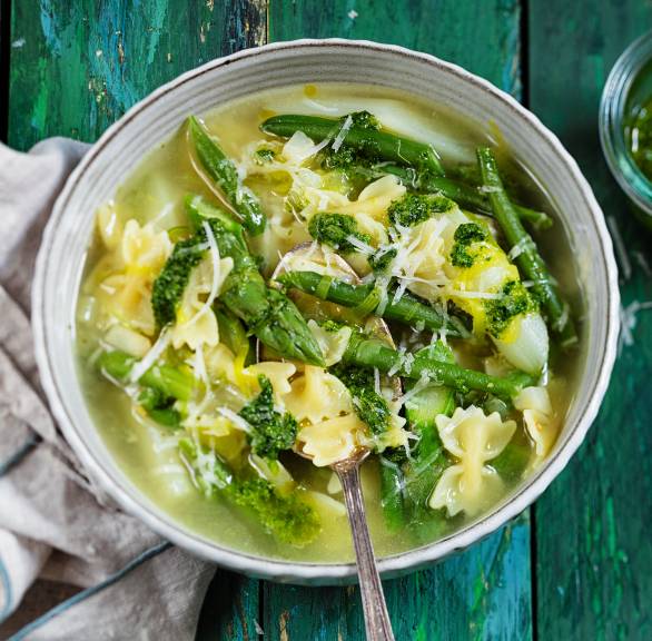 Grüne Minestrone mit Einlage aus grünem Spargel, Bärlauch und Nudeln in einem Suppenteller