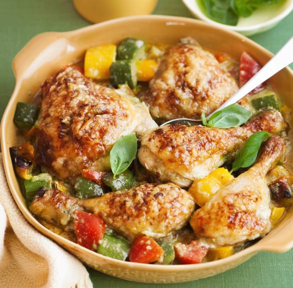 Gebackene Hähnchenkeulen mit Käsekruste auf italienischem Gemüse in einer Auflaufform