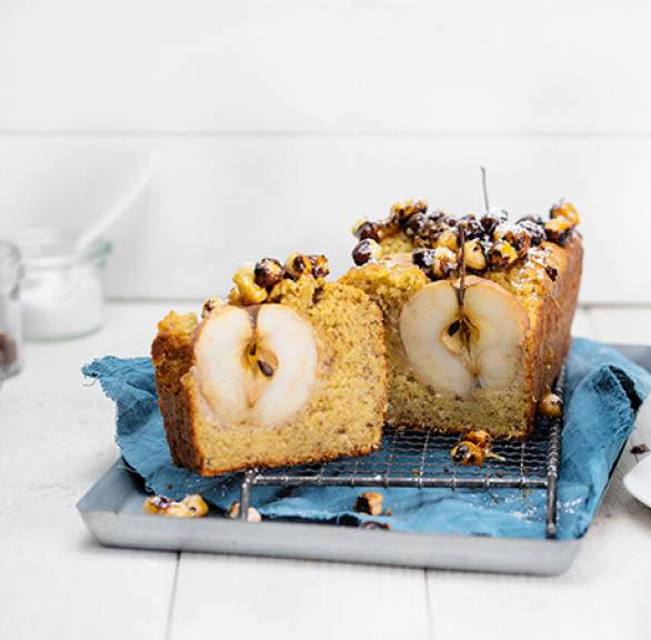  Haselnuss-Gewürzkuchen mit ganzen Äpfeln halbiert auf einem Kuchengitter