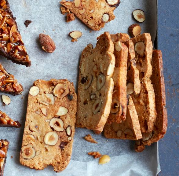 Haselnussplätzchen mit Amaretto in feinen Scheiben auf einem Backblech mit anderen Plätzchen