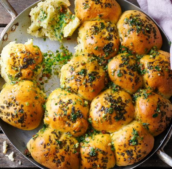 Hefebrötchen-Sonne mit selbst gemachter Bärlauchbutter in einer ofenfesten Pfanne auf einem Holztsich