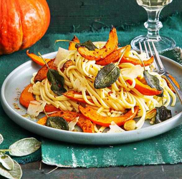 Linguine auf einem Teller getoppt vom Kürbisspalten