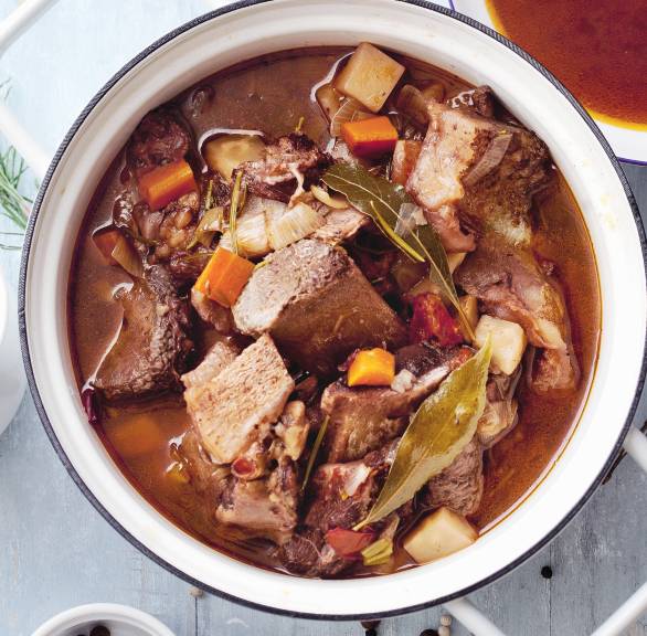 Selbst hergestellter Kalbsfond in einem Kochtopf auf einem Tisch