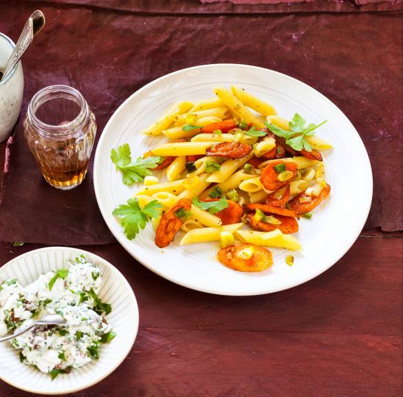 Pastapfanne auf einem Teller, daneben Dip in einer Schale