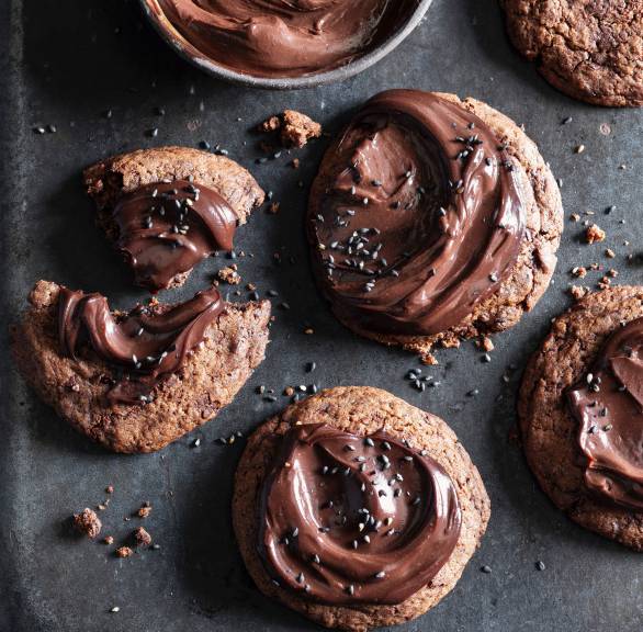 Chocolate Cookies mit Schokoladen-Ganache bestrichen und getoppt mit schwarzem Sesam auf einem Plätzchenteller