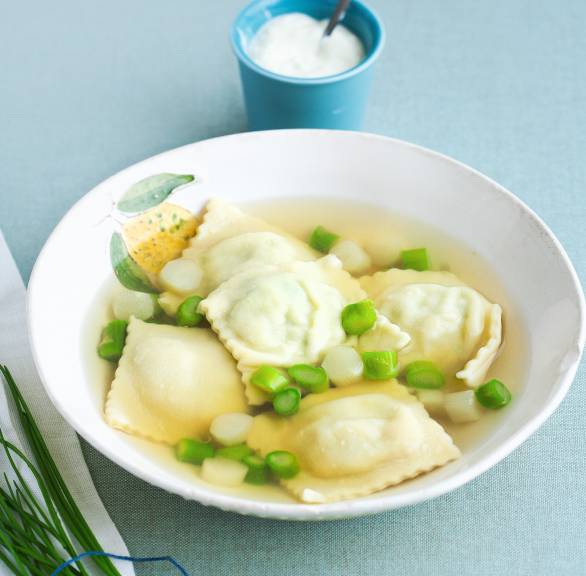 Klare Spargelsuppe mit einer Einlage aus selbstgemachten Bärlauch-Teigtaschen in einem tiefen Teller