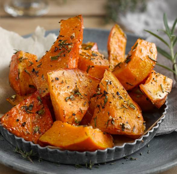 Kürbisecken mit frischen Kräutern garniert auf einem Teller