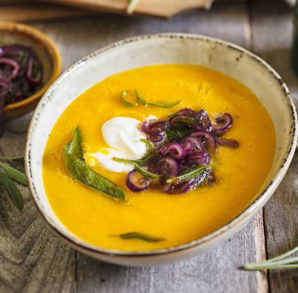 Selbstgekochte Kürbissuppe getoppt mit karamellisiertem Salbei, roten Zwiebelringen und Ziegenfrischkäse-Creme