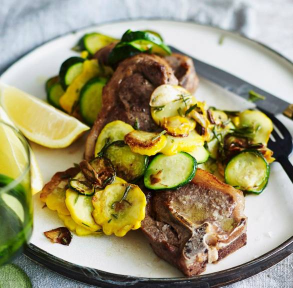Lammkoteletts auf einem Teller getoppt vonKürbis-Zucchini-Gemüse