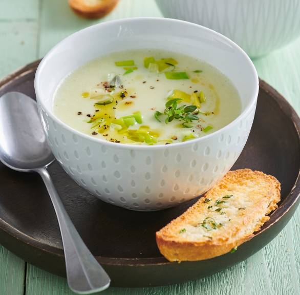 Lauchcremesuppe in zwei Suppentellern, daneben selbstgemachte Knoblauch-Crostini als Beilage