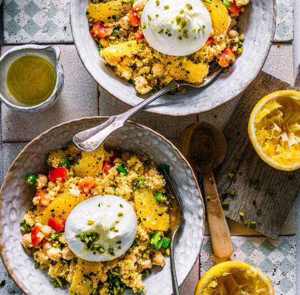 Zwei Schalen Couscoussalat mit Kichererbsen getoppt von Burrata und Pistazien