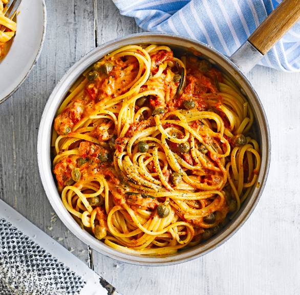 Linguine in Tomaten-Sahne-Soße mit Kapern angerichtet auf einem Pastateller