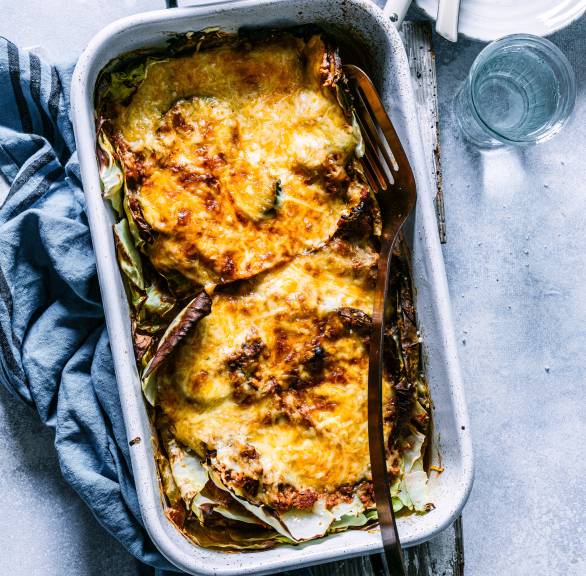 Low-Carb-Lasagne mit Käsedecke angeschnitten in einer Auflaufform von oben auf einem Tisch