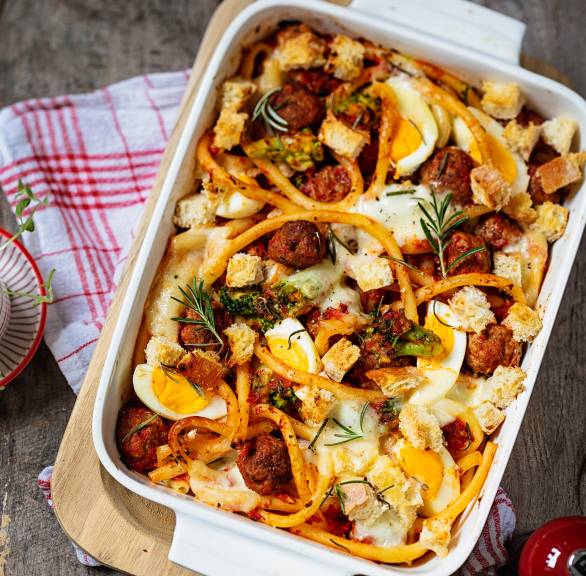 Auflauf aus Nudeln, Hackbällchen, Brokkoli und Eiern in einer Auflaufform auf einem Tisch