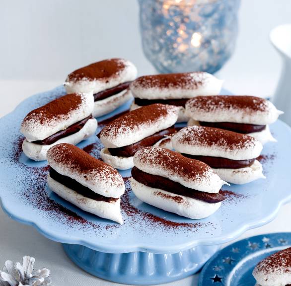 Doppeldecker-Baiser-Plätzchen mit Mandeln und Schokoladenfüllung auf einer Tortenplatte