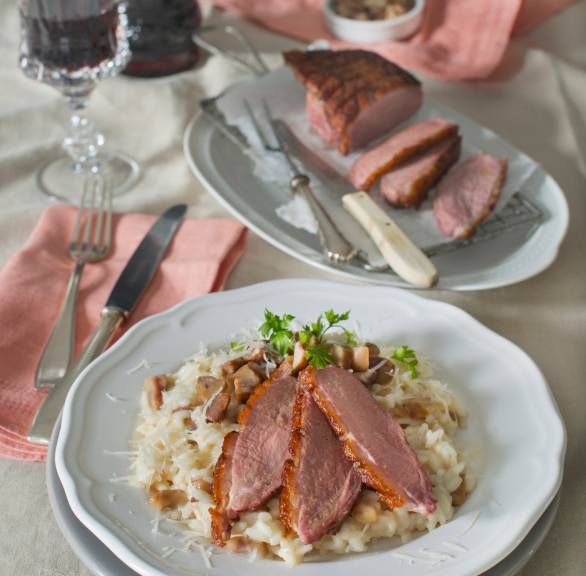 Entenbrust in Scheiben auf Risotto angerichtet auf einem weihnachtlich dekorierten Tisch