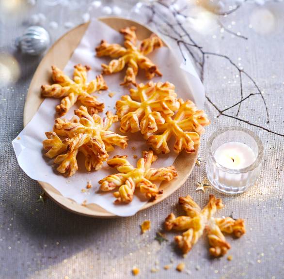  Selbstgebackene Schneeflocken-Plätzchen aus Blätterteig auf einem Plätzchenteller