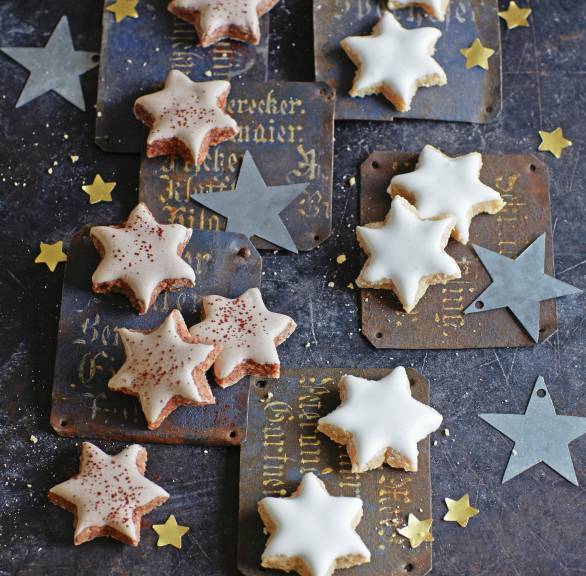 Selbstgebackene Marzipan-Nuss-Plätzchen in Sternform mit Glasur auf weihnachtlichen Karten