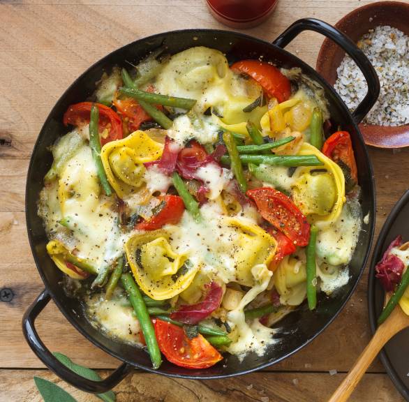 Mit Mozzarella gratinierte Tortellini mit grünen Bohnen, Bresaola und Tomaten