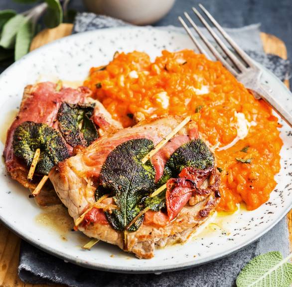 Saltimbocca alla romana auf einem Teller, daneben Risotto und Soße