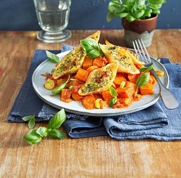 Riesige, gefüllte Muschelnudeln angerichtet auf einem Teller mit Kürbis-Gemüseragout